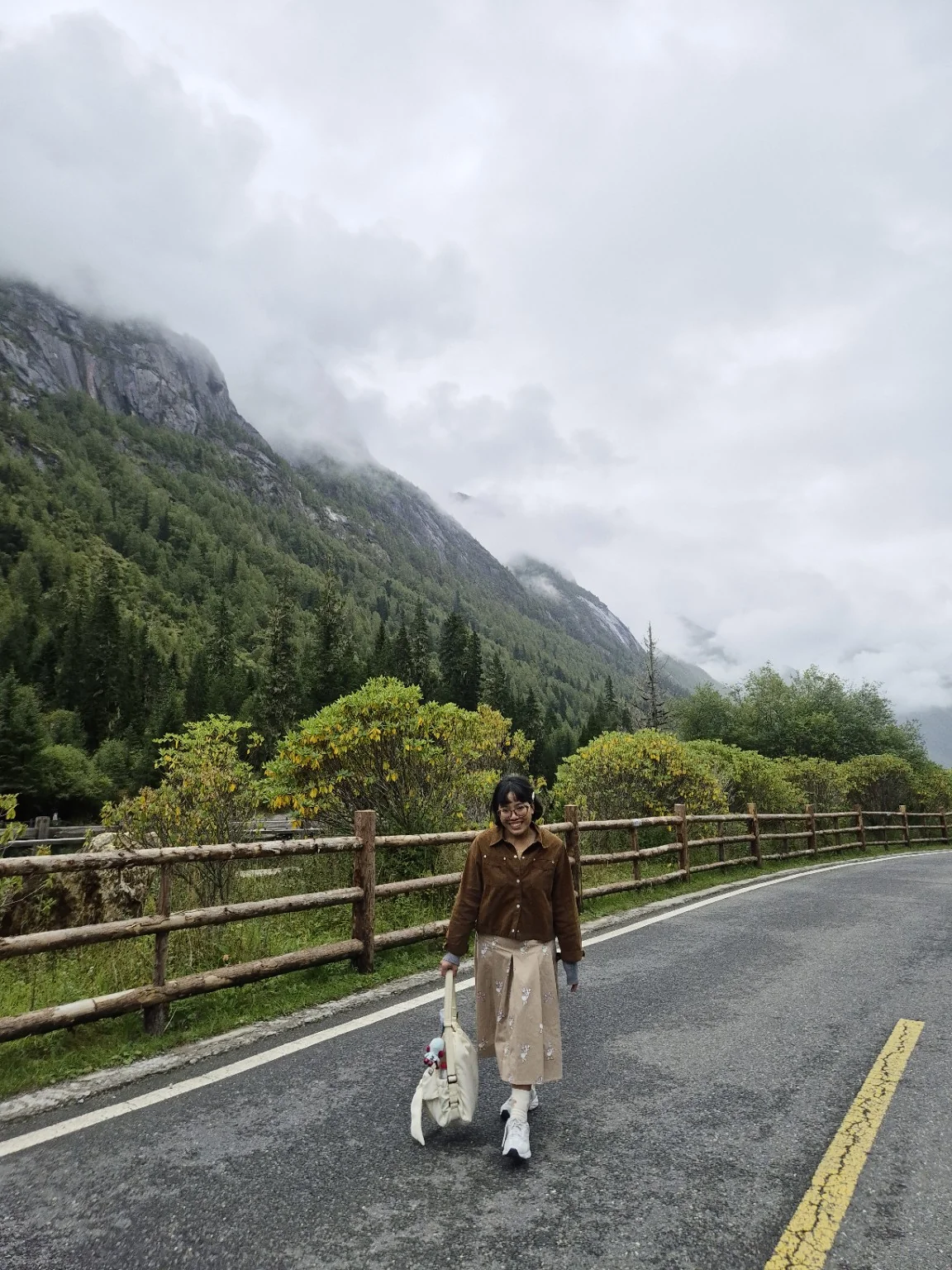 Mazwani walking along a mountain road with a canvas bag
